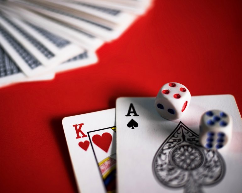 Blackjack king and ace dice and a deck of cards on a red background