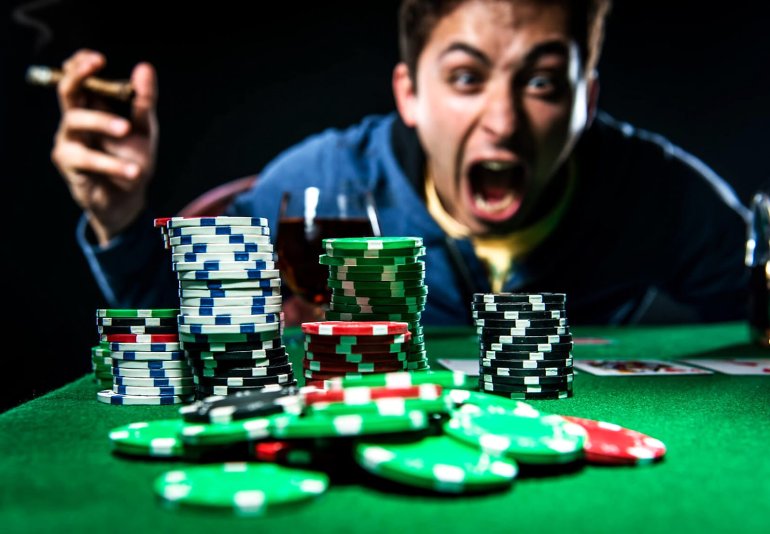 A man in anger yells at a stack of chips with a cigar in his hands