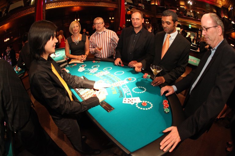 A group of players checks for open cards in blackjack
